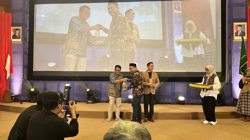 Direktur Operasional PT. Rakosa (Voks Radio Jogja), Drs. Ali Sugiyanto menerima piala dan piagam penghargaan dari KPID DIY 